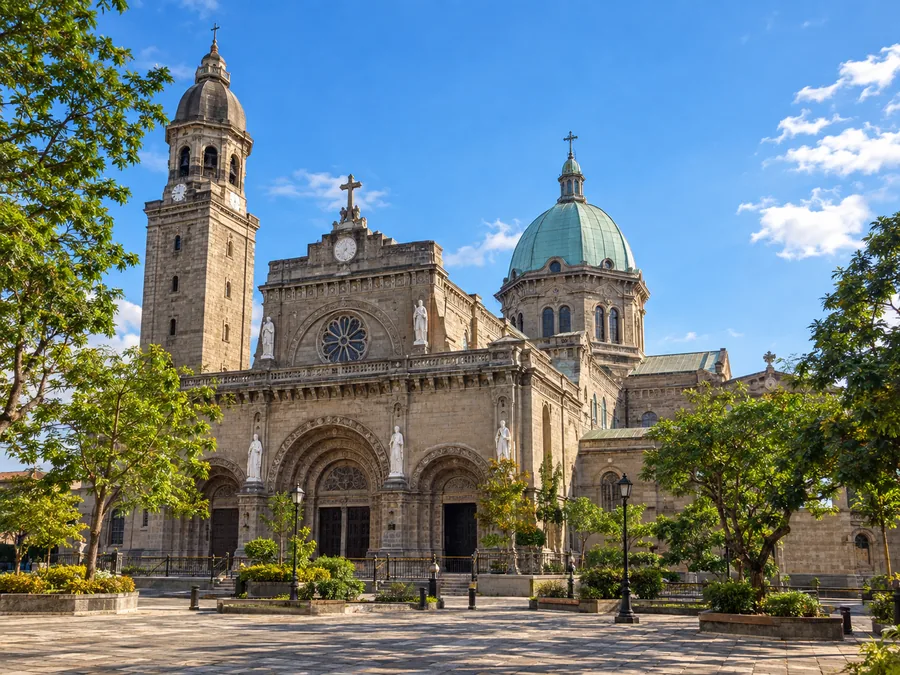 Die Steinfassade, die Kuppel und der Glockenturm der Kathedrale von Manila in Intramuros an einem sonnigen Nachmittag